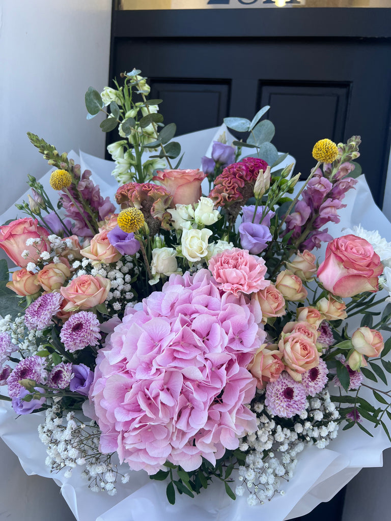 fresh multicoloured bouquet in pastel colours, including hydrangeas, roses, chrysanthemums, spray roses, crispedia, gyposophilia, eucalyptus. 