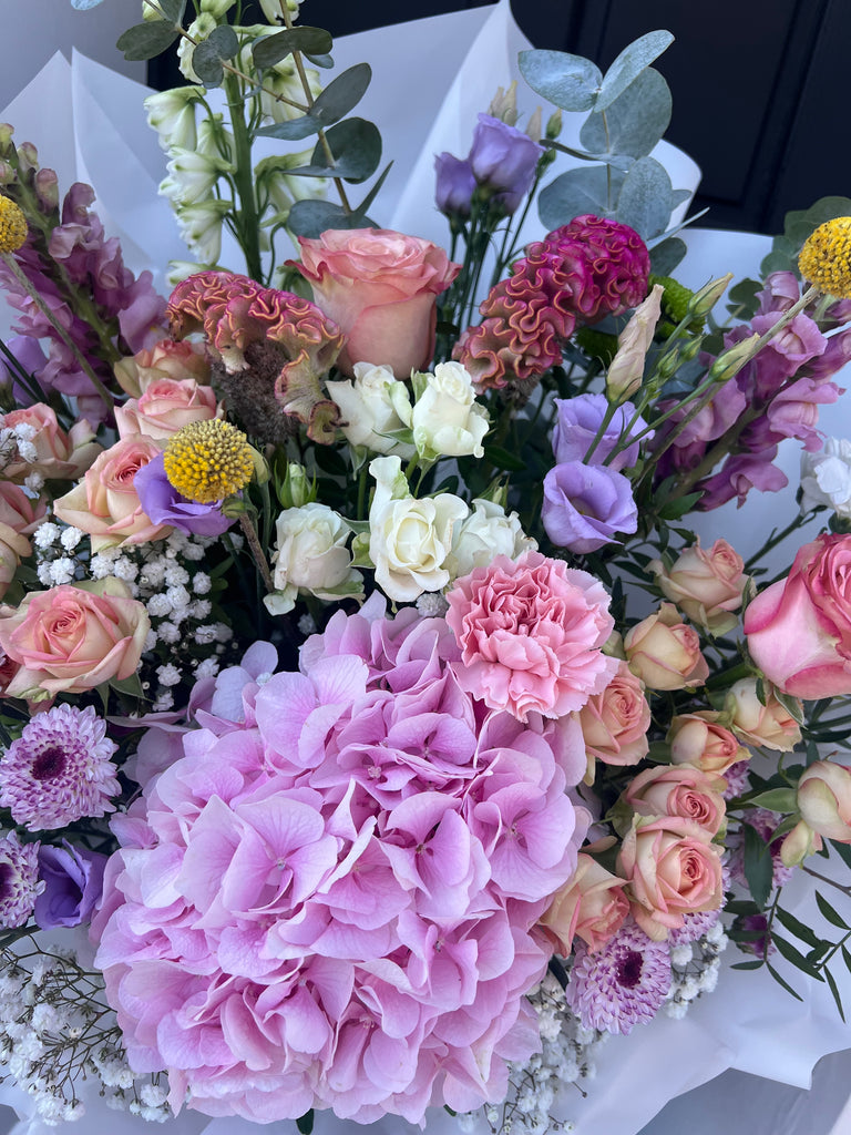 fresh multicoloured bouquet in pastel colours, including hydrangeas, roses, chrysanthemums, spray roses, crispedia, gyposophilia, eucalyptus. 