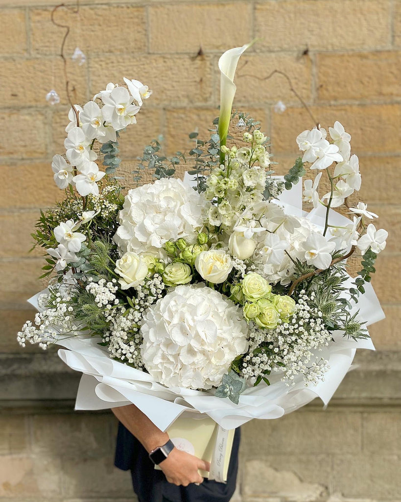 all white bouquet with orchids, hydrangeas and roses