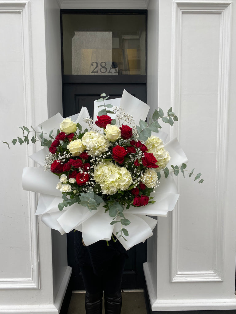 red and white flowers with eucalptus sprigs throguhout